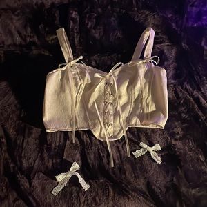 cream colored corset top, with ribbon sequence in the front